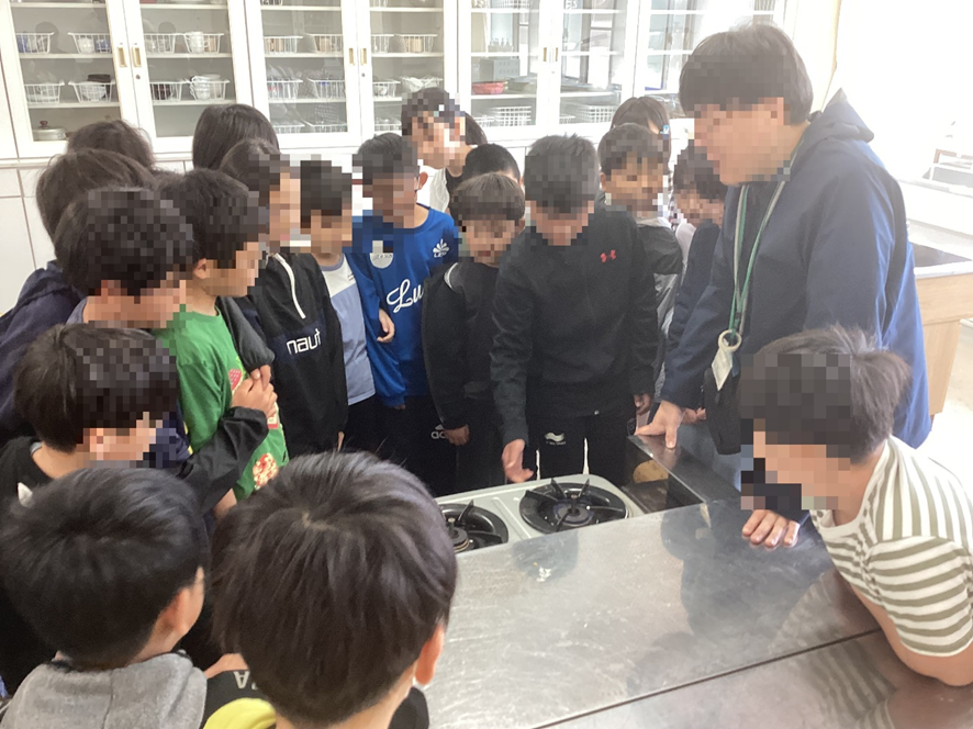 みんなでガスコンロの使い方を確認するようす