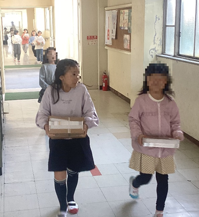 プリントを運ぶ児童