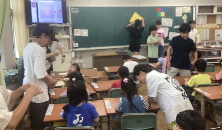 1年生に折り鶴を教える6年生1