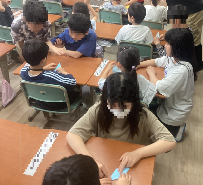 1年生に折り鶴を教える6年生3