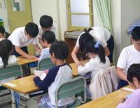 6年生がつるの折り方を教える様子