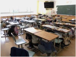 頭を守るために机の下に