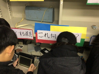 古い機械を手にとる児童